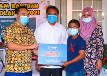 WAN Saiful Wan Jan (kiri) menyampaikan sumbangan pembukaan akaun SSPN sempena Program Bantuan Persekolahan 2021 yang dianjuran oleh PTPTN serta Perdasama kepada 410 pelajar daripada keluarga golongan B40 sekitar Negeri Sembilan di Senawang, Seremban hari ini. - UTUSAN/MUHAMMAD IZZAT TERMIZIE