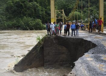 PENDUDUK melihat kerosakan yang disebabkan oleh hujan lebat akibat Taufan Eta di sebuah jambatan di sungai Cahaboncito di Panzos, Alta Verapaz, di utara Bandar Guatemala. - AFP.