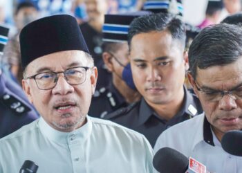 ANWAR Ibrahim (kiri) sentiasa menegaskan bahawa beliau memegang jawatan Perdana Menteri bukan untuk menganiaya, menekan atau menzalimi sesiapa. – UTUSAN/FARIZ RUSADIO