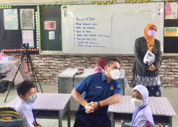 MOHD. Radzi Md. Jidin beramah mesra dengan murid ketika meninjau hari pertama sesi persekolahan secara bersemuka di SK Syed Idrus, Chemor, Ipoh, Perak, hari ini. - UTUSAN/MOHAMAD HAFIZI MOHD. SAID