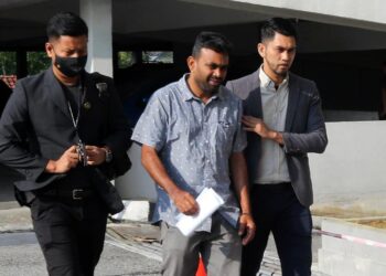 N. SURESH RAO (tengah) diiringi pegawai SPRM ke Mahkamah Sesyen Ipoh hari ini bagi menghadapi pertuduhan memberi rasuah kepada anggota polis minggu lalu. - UTUSAN