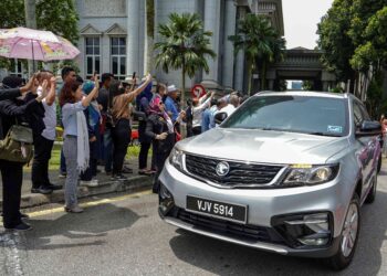 Penyokong Najib Tun Razak melambai tangan ketika kenderaan membawa bekas Perdana Menteri itu meninggalkan Istana Kehakiman, Putrajaya, semalam. – UTUSAN/FARIZ RUSADIO