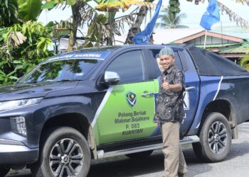 WAN RAZALI Wan Nor menunjukkan isyarat bagus ketika melakukan ziarah rumah ke rumah di Kampung Peramu di Kuantan, Pahang. - FOTO/SHAIKH AHMAD RAZIF