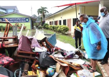 MOHD. Redzuan Yusof (kanan) melihat peralatan sekolah yang rosak akibat banjir di Sekolah Jenis Kebangsaan (SJK) Tamil Durian Tunggal, Alor Gajah, Melaka. UTUSAN/ RASUL AZLI SAMAD