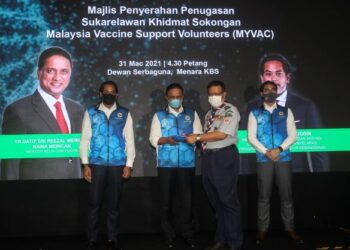 REEZAL Merican Naina Merican menyerahkan vest kepada Sukarelawan Persatuan Pengakap, Ahmad Sabri Saad (dua kanan) pada Majlis Penyerahan Penugasan Sukarelawan Khidmat Sokongan Malaysia Vaccine Support Volunteers (MYVAC) di Menara KBS di sini, hari ini. - UTUSAN/ FAISOL MUSTAFA