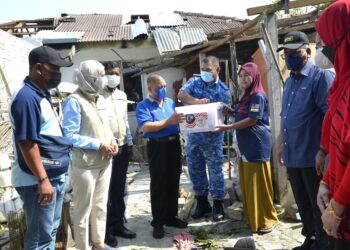 SAARANI Mohamad (empat dari kiri) menyampaikan sumbangan kepada mangsa ribut di Klebang, Ipo, Perak, hari ini. - UTUSAN/ZULFACHRI ZULKIFLI