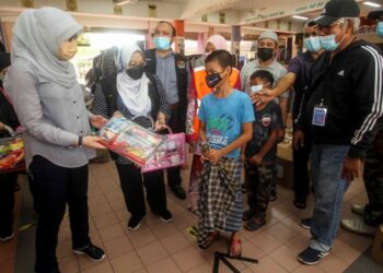 RINA Mohd. Harun (kiri) menyerahkan barangan permainan kepada kanak-kanak ketika mengadakan lawatan ke PPS Kota Warisan di Sekolah Kebangsaan Kota Warisan, Sepang, Selangor. - UTUSAN/FAISOL MUSTAFA