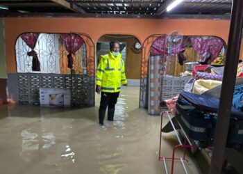 SHAMSUDIN Mamat meninjau salah sebuah rumah mangsa banjir di Kampung Charok Bakap, Parit Panjang, Baling, Kedah, hari ini. - UTUSAN/NORLIA RAMLI