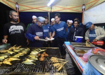 ROSLI Abdul Jabar (depan, dua dari kiri) menyantuni anak muda dalam program bersama golongan itu di Sungai Isap Murni di Kuantan, Pahang. - FOTO/SHAIKH AHMAD RAZIF