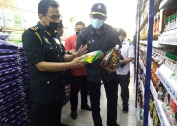 Rosol Wahid bersama  Azman Adam memeriksa harga minyak masak di sebuah pasar raya di Jalan Lama Kuala Selangor, Sabak Bernam, Selangor hari ini-UTUSAN/MOHAMAD NAUFAL MOHAMAD IDRIS