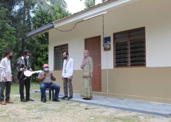 ABDUL Razak Harun (tengah) menadah tangan bersyukur selepas rumah untuk bapanya kini siap sambil diperhatikan Mohd Isam (dua, kiri) dan Suhaini Hazli (dua, kanan) sempena Majlis Penyerahan Rumah Bina Baharu PPRT di Kampung Baru Sungai Kepong, Tampin, Negeri Sembilan,  hari ini. - UTUSAN//NOR AINNA HAMZAH.