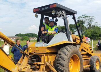 SAARANI Mohamad mengendalikan jengkaut ketika menyempurnakan simbolik perasmian projek menggantikan jambatan Sungai Kinchap di Kampar, Perak. - UTUSAN/ASLIZA MUSA