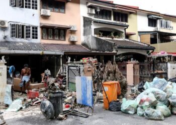 SEORANG penduduk, Sivanesan, 68, termenung melihat longgokan sampah di hadapan rumahnya akibat banjir kilat di Taman Sri Muda, Shah Alam, Selangor. – UTUSAN/ZULFADHLI ZAKI