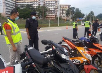 NOR Omar Sappi (kiri) melihat motosikal yang disita dalam operasi membanteras aktiviti samseng jalanan menerusi sekatan jalan raya di Kilometer 6 Jalan Teluk Muroh-Lumut semalam. - FOTO/SHAMSUL KAMAL AMARUDIN