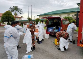 SEBAHAGIAN anggota bomba melakukan persiapan sebelum melakukan kerja-kerja sanitasi di Penjara Pokok Sena, Alor Setar, Kedah semalam.