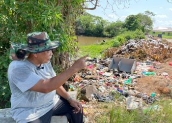 RAMLI Mihat menunjukkan tapak pembuangan sampah haram di Kampung Batu 7 1/2 Bukit Rambai, Melaka. - UTUSAN/DIYANATUL ATIQAH ZAKARYA