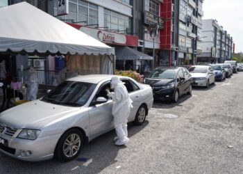 Deretan kenderaan menunggu giliran untuk melakukan ujian saringan Covid-19 secara pandu lalu di Megaklinik Zahran Bandar Baru Bangi, Selangor, semalam. – UTUSAN/MUHAMAD IQBAL ROSLI