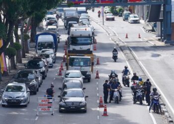 ANGGOTA keselamatan memeriksa dokumen pengguna lalu lintas di sebuah sekatan jalan raya di Jalan Loke Yew baru-baru ini. - FOTO/MUHAMAD IQBAL ROSLI