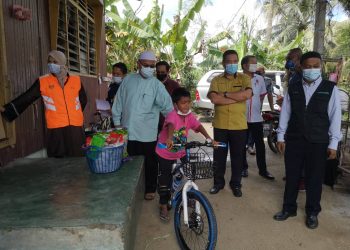 MOHD. Ashraff  Mokhtar mencuba basikal yang diterimanya di Kampung Telaga Gayong, Pasir Puteh, hari ini. - UTUSAN/TOREK SULONG