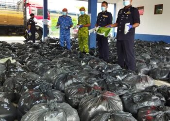 SHAMSUDIN Mamat (kanan) menunjukkan sebahagian bungkusan daun ketum yang dirampas di SJR Jerai, Jalan Kupang-Gerik, Kupang, Baling, hari ini. - UTUSAN/NORLIA RAMLI