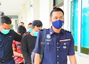 ANGGOTA polis membawa ketiga-tiga tertuduh ke Mahkamah Sesyen Pasir Mas, Kelantan hari ini. - UTUSAN/YATIMIN ABDULLAH