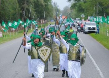 SEBAHAGIAN peserta yang membawa replika senjata pada perarakan sempena program Himpit 2023 di Setiu, Terengganu, Jumaat lalu. - MEDIA SOSIAL