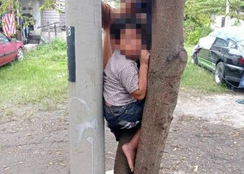 BUDAK lelaki enam tahun yang tersepit  antara pokok dan tiang elektrik di Kampung Sungai Bakap, Batu Gajah, dikeluarkan pasukan bomba tanpa sebarang kecederaan. - IHSAN JBPM