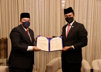 ABDUL Ghani Salleh (kiri) menyerahkan keputusan PRN Johor kepada Azmi Rohani untuk diberikan kepada Istana Johor, hari ini.