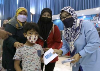 WIDIAWATI Abudzar menyerahkan sumbangan kepada salah seorang murid menerusi bantuan daripada Yayasan Bank Rakyat dengan jumlah peruntukan sebanyak RM210,000 di Sabak Bernam, Selangor.