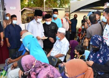 MOHD. Shafie Apdal menyampaikan sumbangan Ramadan kepada golongan yang memerlukan di Kampung Sembulan di Kota Kinabalu, Sabah, semalam.