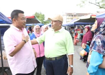 MOHD. SHARKAR Shamsudin (kiri) ketika mengadakan tinjauan mesra di Pekan Sehari Lanchang di Temerloh, Pahang.