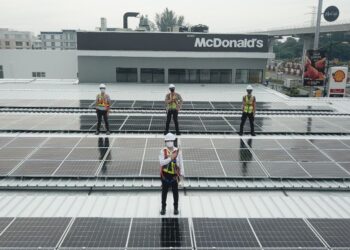 Seow Lee Ming (hadapan) bersama pasukan Shell di atas bumbung sebuah stesen minyak Shell yang dipasang panel solar.