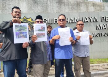 MOHD. Shukor Mustaffa (dua kiri) menunjukkan dokumen laporan kepada SPRM di perkarangan ibu pejabat SPRM, Putrajaya.
