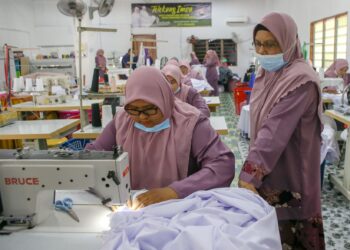 SITI HAJAR (kanan) sentiasa turun padang untuk memberi tunjuk ajar dan mengasah kemahiran pekerja di 
bengkel miliknya yang terletak di Kubur Panjang, Pokok Sena. Kedah.