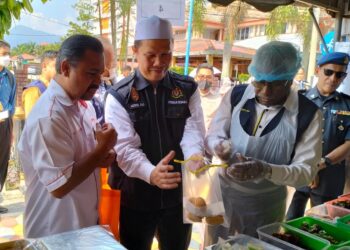 A. SIVANESAN (kanan)  mengambil sampel makanan untuk dianalisis pada pelancaran Op Ramadan di Bazar Ramadan Tapah  semalam. - UTUSAN