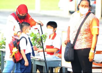 SEORANG murid menjalani pemeriksaan suhu sebelum memasuki kelas pada hari pertama persekolahan tahun satu hingga empat di SK Taman Perling 3 di Johor Bahru hari ini. -GAMBAR/RAJA JAAFAR ALI