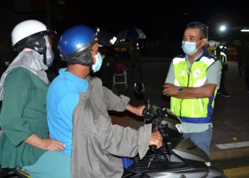 ADZLI Abu Shah (kanan) bertanyakan sesuatu dengan penunggang motosikal  di  sekatan jalan raya berikutan Perintah Kawalan Pergerakan di Bedong, Sungai Petani malam semalam.