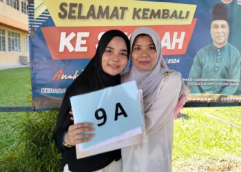 ARISSA Sofiya Abd. Rahman menunjukkan keputusan SPM sambil ditemani ibunya, Salma Hamat di SMK Gunung Rapat di Ipoh hari ini. - UTUSAN