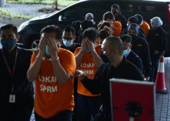 ENAM kakitangan sebuah syarikat swasta di bawa ke Mahkamah Majistret untuk direman bagi bantu siasatan kes tuntutan palsu sebanyak RM900,000 di Shah Alam, Selangor, hari ini. - UTUSAN/ZULFADHLI ZAKI