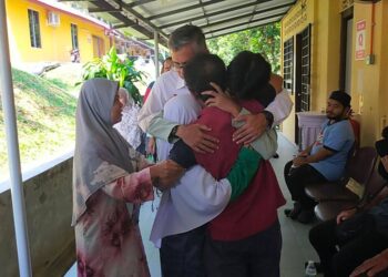 NASARUDDIN Abu Bakar (tengah) memeluk dua anaknya, Ahmad Danish Basyir dan Siti Nur Khadijah sebaik sahaja tiba di pekarangan Hospital Kampar hari ini. - UTUSAN/ASLIZA MUSA