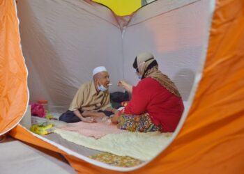 SEORANG warga emas, Ismail Abdullah menikmati makanan di PPS Veterinar Guchil, Kuala Krai, Kelantan hari ini. - UTUSAN/BAHRUDDIN HATTA