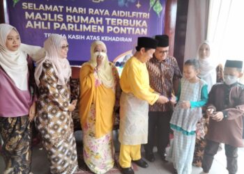 AHMAD Maslan menyampaikan duit raya kepada kanak-kanak yang hadir ke Majlis Rumah Terbuka Ahli Parlimen Pontian di Rumah Citra Benut, Pontian, Johor. -UTUSAN/MUHAMMAD ZIKRI