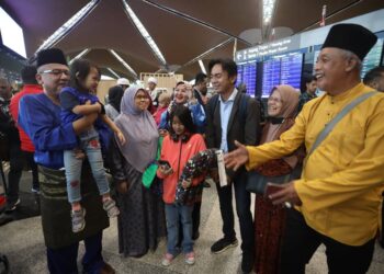 SAMSIAH Misron (kanan) ketika menyambut ketibaan anaknya Amirul Husni Sahar (tiga kanan) di KLIA, Sepang, Selangor. - UTUSAN/FAISOL MUSTAFA