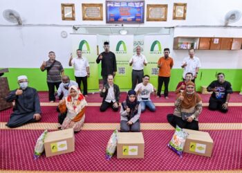 NOR Azman Zainal (berdiri, tiga kanan) dan Muhammad Roger James Arnold (berdiri, tiga kiri) pada majlis penyerahan sumbangan kepada asnaf, muamalaf di Surau Al-Insaniah, PPR Lembah Subang 1, baru-baru ini.