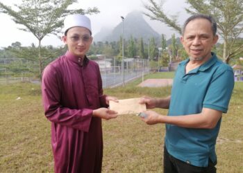 RAZAK Daud (kanan) menyampaikan sumbangan tabung wakaf RM27,000 kepada imam masjid di Kemboja, Zulkarnain Hussain di Felda Jengka 25 di Temerloh, Pahang semalam. - UTUSAN/SALEHUDIN MAT RASAD