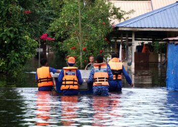 ANGGOTA Angkatan Pertahanan Awam (APM) membawa keluar penduduk yang terjejas banjir di Lorong Mesra, Batu 7 1/2, Jalan Changkat Jong, Teluk Intan, Perak, kelmarin. - UTUSAN/ZULFACHRI ZULKIFLI