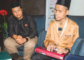 MUHAMMAD Iman Jamaludin yang merupakan peserta OKU kategori hafazan menggunakan eBraille untuk menghafal al-Quran dan membacanya sambil diperhatikan oleh pereka eBraille Shaharil Mad Saad daripada UTM selepas memperdengarkan bacaannya pada pertandingan Tilawah dan Hafazan Al quran Peringkat Kebangsaan di Pusat Islam Iskandar Johor Bahru.