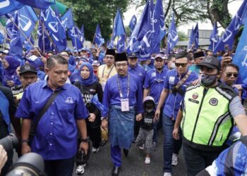 JOHARI Abdul Ghani diiringi penyokong BN  tiba di Sekolah Menengah Kebangsaan Aminuddin Baki untuk proses penamaan calon PRU15.