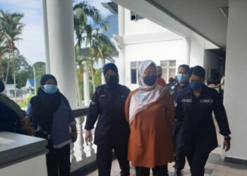 NORHAYATI Serurahman diiring keluar anggota polis di Mahkamah Majistret, Ayer Keroh, Melaka. - UTUSAN/MUHAMMAD SHAHIZAM TAZALI 