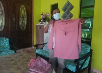 AWIE menunjukkan baju Melayu berwarna merah jambu yang akan dipakai pada Hari Raya Aidilfitri ketika ditemui di rumahnya di Kampung Batu 24, Hulu Terengganu, semalam. - UTUSAN/NOOR HAYATI MAMAT